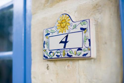 a clock on the side of a wall with a flower on it at Ta' Bertu Host Family Bed & Breakfast in Ħal Far
