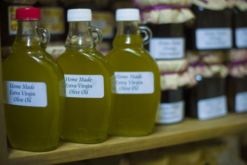 a row of bottles of olive oil on a shelf at Ta' Bertu Host Family Bed & Breakfast in Ħal Far