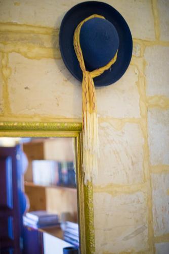 a hat and a mirror on a wall at Ta' Bertu Host Family Bed & Breakfast in Ħal Far