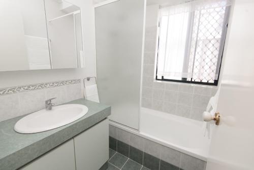 a white bathroom with a sink and a mirror at Caversham B&B in Perth