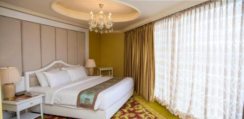 a bedroom with a bed and a chandelier at The Grand Kandyan in Kandy