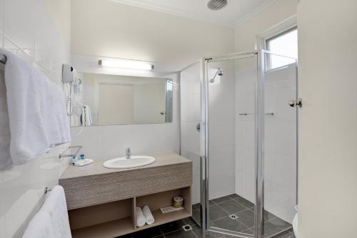 a bathroom with a sink and a shower at Adelaide Road Motor Lodge in Murray Bridge