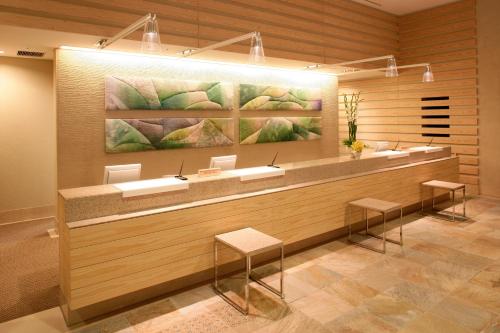 a lobby with a reception counter with stools at City Plaza Osaka in Osaka