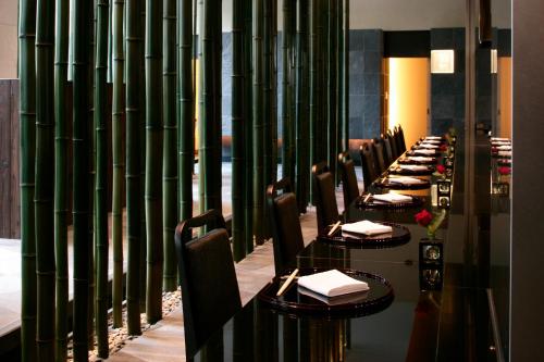 a row of tables in a restaurant with green bamboo walls at City Plaza Osaka in Osaka