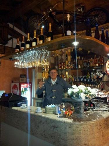 a man standing behind a bar holding a wine glass at Agriturismo Cannavota in Follonica