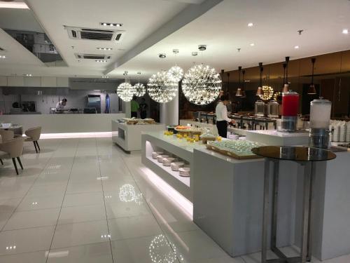 クアラルンプールにあるCosmo Hotel Kuala Lumpurの食べ物が置かれたカウンターのあるレストラン