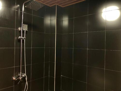 a bathroom with a shower with black tiles at Lantern Hotel in Hohhot