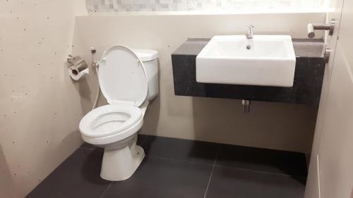 a bathroom with a white toilet and a sink at Rangsit Residence in Ban Talat Rangsit