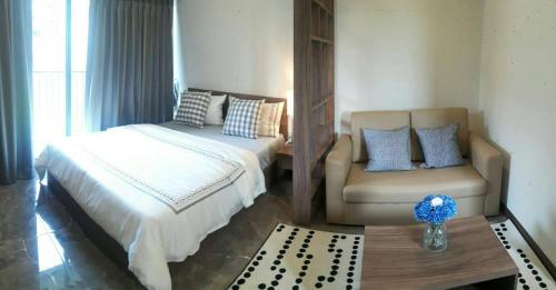 a bedroom with a bed and a couch and a chair at Rangsit Residence in Ban Talat Rangsit