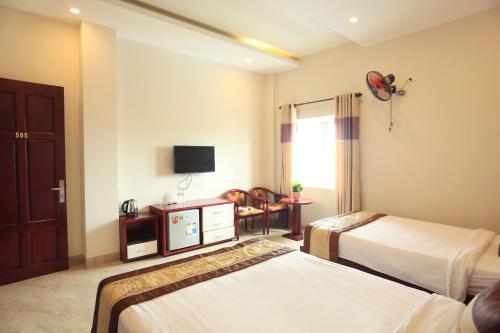 a hotel room with two beds and a television at Phuong Linh Hotel in Danang