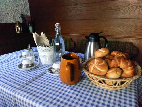 a table with a basket of bread and a bottle of wine at Haus Schneeberg mit Hochkönig Card in Mühlbach am Hochkönig