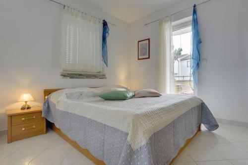 a bedroom with a bed and a window at Apartman Mirna in Premantura