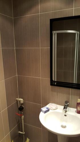 uma casa de banho com um lavatório e um espelho em City Sandanski em Sandanski