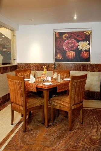 a dining room with a wooden table and chairs at Pan Asia Continental in Kolkata
