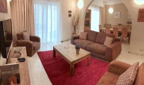 a living room with couches and a coffee table at Sands Apartments in St Paul's Bay