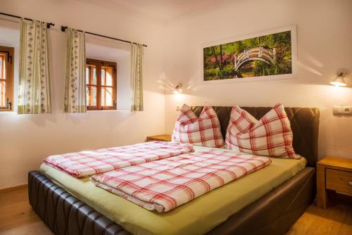 a bed with pillows on it in a room at Landhaus Moser in Leutschach