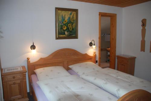 グライナウにあるFerienwohnung Renateのベッドルーム1室(ベッド2台付)が備わります。壁には絵画が飾られています。