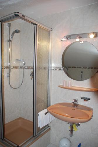 a bathroom with a shower and a sink and a mirror at Ferienwohnung Renate in Grainau
