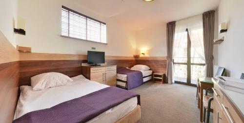 a hotel room with two beds and a television at Willa Focus in Mielno