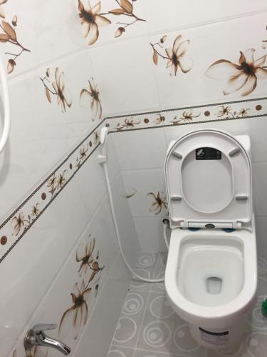 uma casa de banho com um WC com aranhas na parede em Nhà nghỉ Sunrise em Quy Nhon