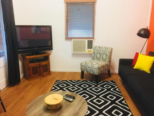 a living room with a couch and a tv and a chair at Cottage on Cork -Laffin Cottage in Winton