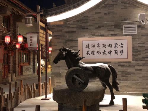 a statue of a horse in front of a building at Lantern Hotel in Hohhot