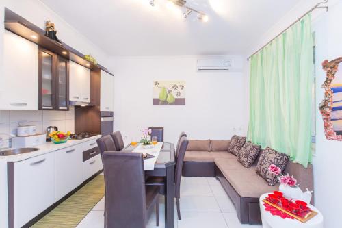 a kitchen and a living room with a couch and a table at Apartment Marinero with FREE parking in Dubrovnik