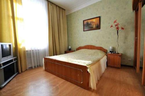 1 dormitorio con 1 cama y TV en Apartments on Bolshaya Morskaya 65, en Mykolaiv
