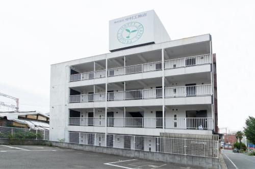 a building with a clock on the side of it at BEEHIVE APARTMENT Moriguchi in Osaka
