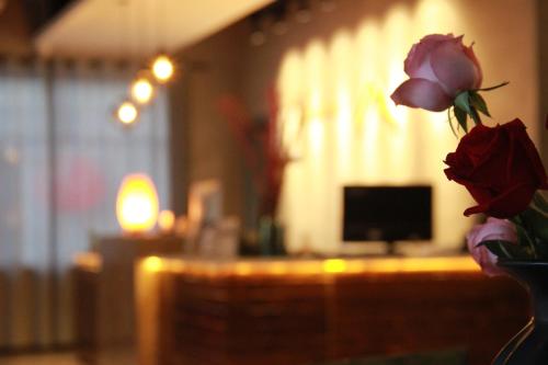 a vase filled with roses in a living room at Lantern Hotel in Hohhot