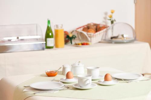 une table avec des coupes d'œufs et des soucoupes dans l'établissement Weingut und Gästehaus Berger, à Gedersdorf