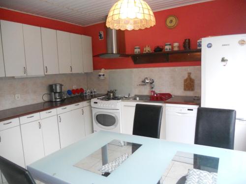 cocina con armarios blancos, lavadora y secadora en Apartament Turystyczny w Stepnicy, en Stepnica