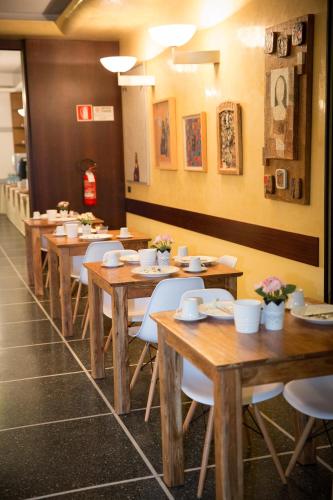 a row of wooden tables and chairs in a restaurant at Art Hotel Milano in Prato