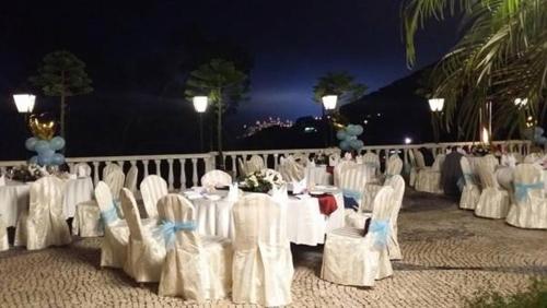 a group of tables and chairs with white tables and chairs at Pousada de Coloane Boutique Hotel in Macau