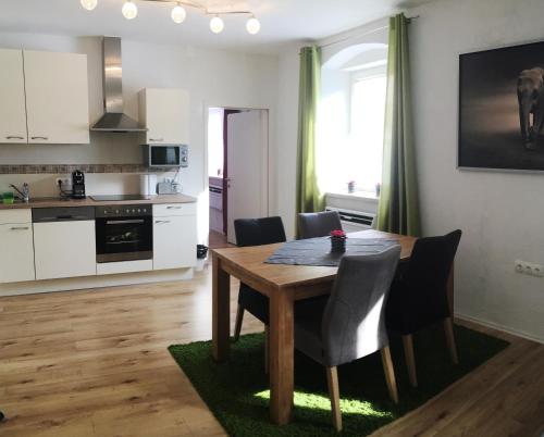 a kitchen and dining room with a wooden table and chairs at Alpenaquarium Grüblsee - FEWO Monika in Vordernberg