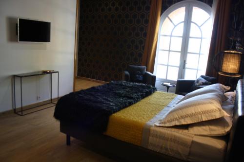 a bedroom with a bed and a window at La Gourgasse Vieille in Béziers