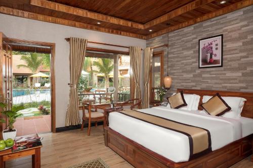 Schlafzimmer mit einem Bett und einem Tisch sowie einer Terrasse in der Unterkunft Golden Topaz Phu Quoc Resort in Phu Quoc