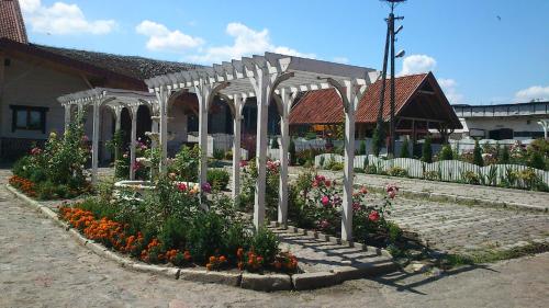 a garden with a white canopy and flowers at Zajazd Eljan-Centrum Noclegowe in Olsztyn