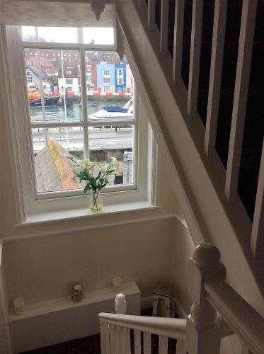 a staircase with a window with a vase of flowers at The Ocean Guest House in Weymouth