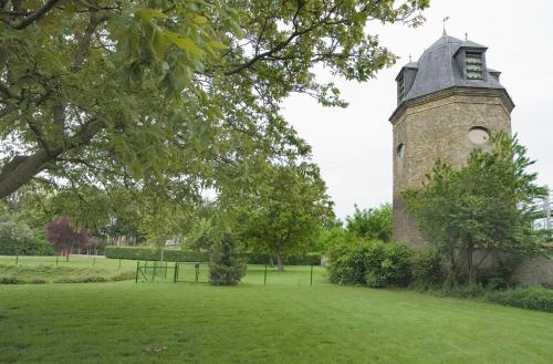 a building with a clock tower in a field at Hotel Oude Abdij in Lo-Reninge