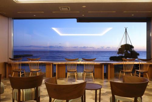 a room with chairs and a view of the ocean at Heiseikan Shiosaitei Hanatsuki in Hakodate