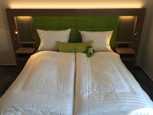 a bed with a teddy bear sitting on top of it at Landhotel Witte-König in Garrel