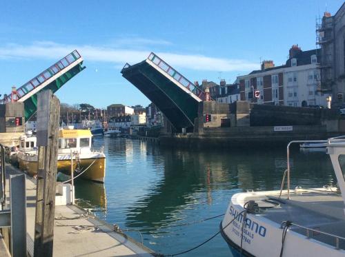 a bridge over a river with boats in the water at The Ocean Guest House in Weymouth