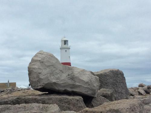 a lighthouse with a large rock in front of it at The Ocean Guest House in Weymouth