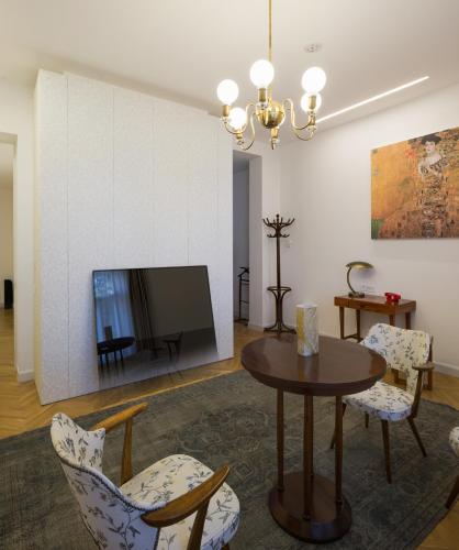 a living room with a table and chairs and a tv at Villa Csonka by Privo in Târgu-Mureş