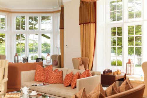 a living room with a couch and some windows at Champneys Forest Mere in Liphook