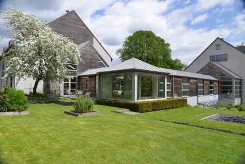 une maison avec un jardin en face dans l'établissement Le Côté Vert, à Waterloo