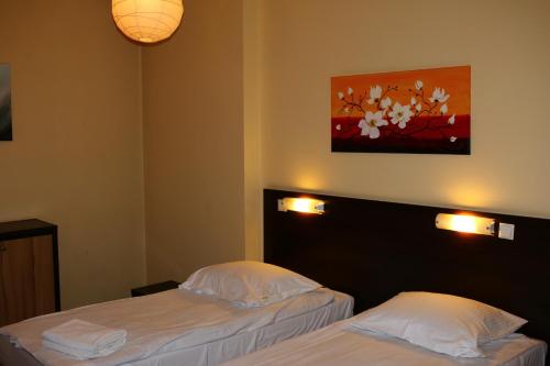 a hotel room with two beds and a painting on the wall at Amicus Żoliborz in Warsaw