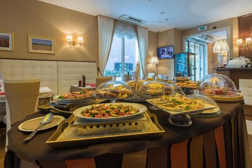 un buffet avec plusieurs assiettes de nourriture sur une table dans l'établissement Holiday home ''Oasi'', à Pula