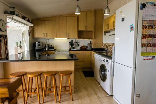 a kitchen with wooden cabinets and a white refrigerator at Beach Cottage in Kleinmond